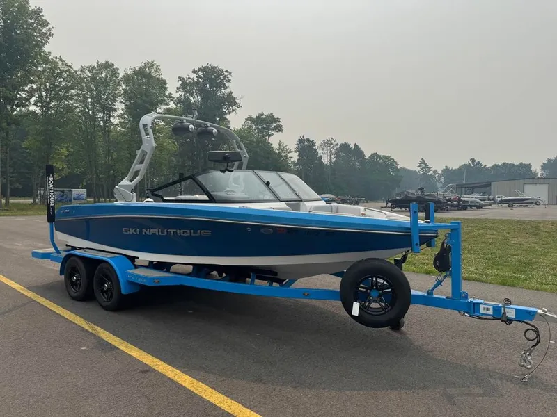 Slide: The Image of A blue and white 2025 Ski Nautique 200 Open Bow on a trailer in a parking lot. - 3