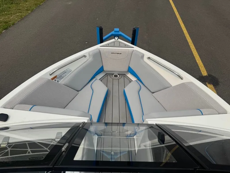Slide: The Image of The image shows the bow of a 2025 Nautique Ski Nautique 200 Open Bow with gray and blue upholstery. - 10