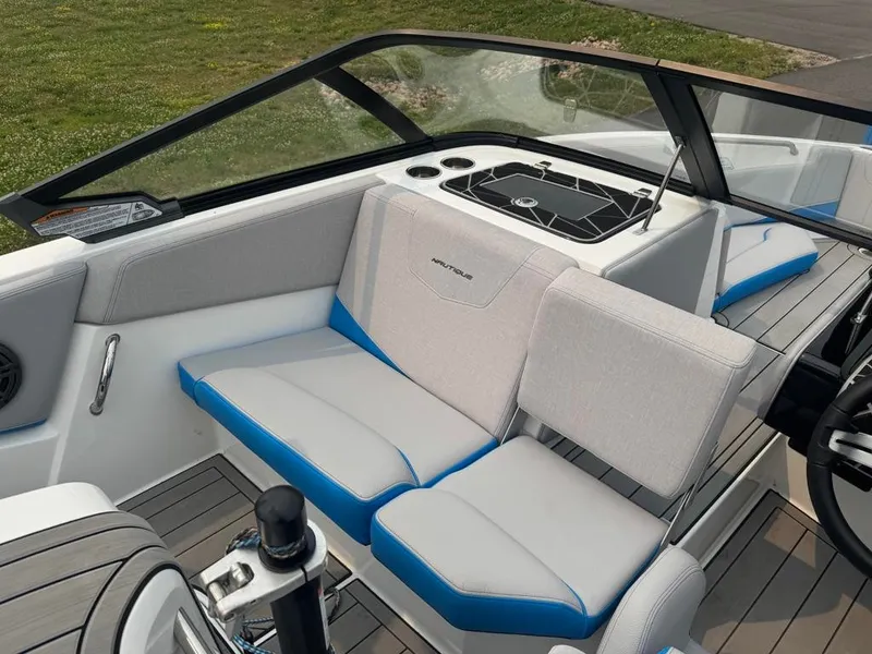 Slide: The Image of The image shows the cockpit of a 2025 Nautique Ski Nautique 200 Open Bow with gray and blue seating. - 16