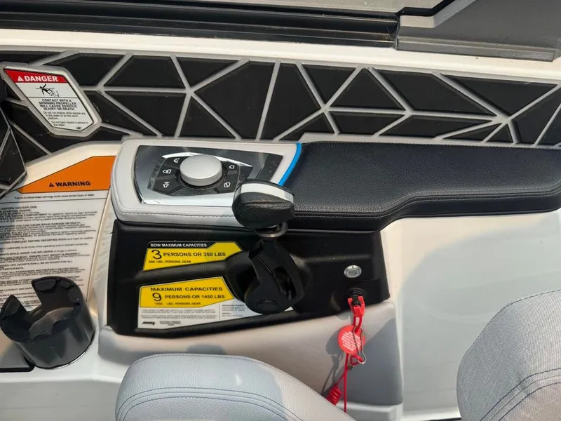 Slide: The Image of The image shows the control panel of a 2025 Nautique Ski Nautique 200 Open Bow with controls and warning labels. - 26