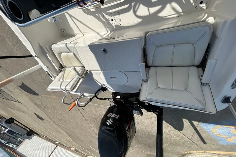 Slide: The Image of 2016 Blue Wave 2000 PureBay boat interior with seating and Suzuki outboard motor. - 10