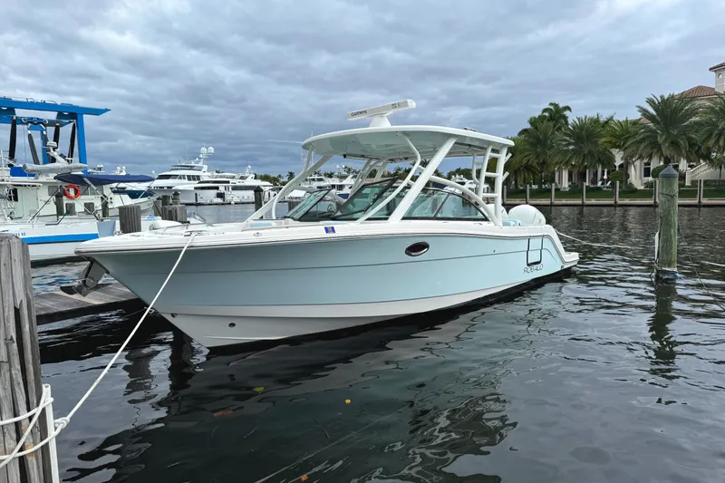 The Image of 2018 Robalo R317 Dual Console boat docked in marina, calm water, cloudy sky. - 0