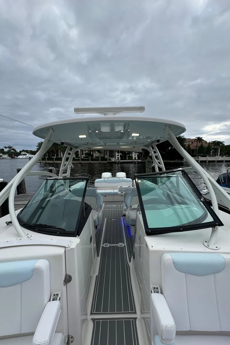 Slide: The Image of 2018 Robalo R317 Dual Console boat with sleek design, docked under cloudy skies. - 14