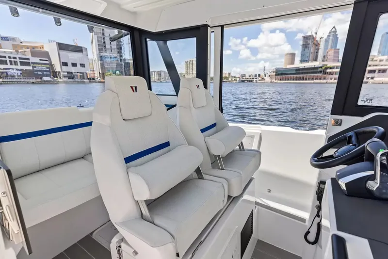 Slide: The Image of Interior view of a modern boat with two cushioned seats and a helm, set against an urban backdrop. - 21