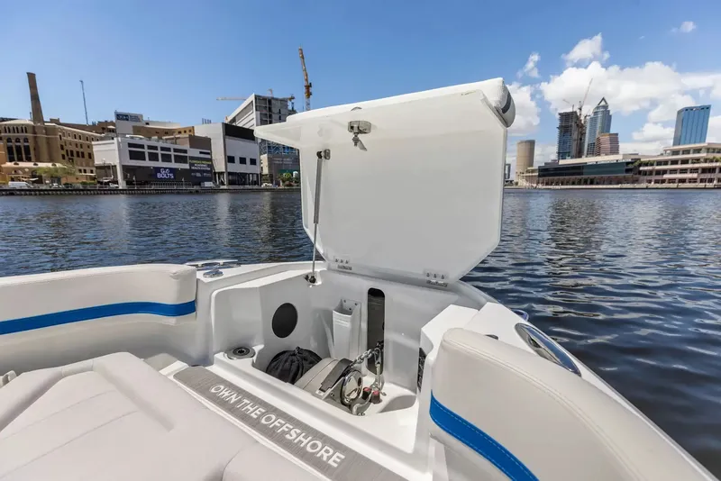 Slide: The Image of The image shows the open deck of a Wellcraft 28 Explorer boat in a harbor with city view. - 32