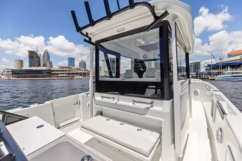 Slide: The Image of The image shows a modern Wellcraft 28 Explorer boat in a harbor with a city skyline in the background. - 13