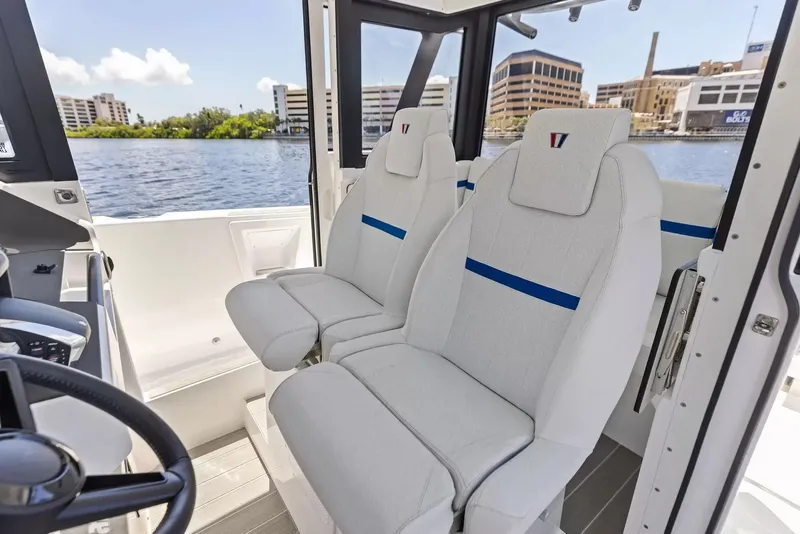 Slide: The Image of Two cushioned seats in a modern boat overlooking an urban waterfront. - 22