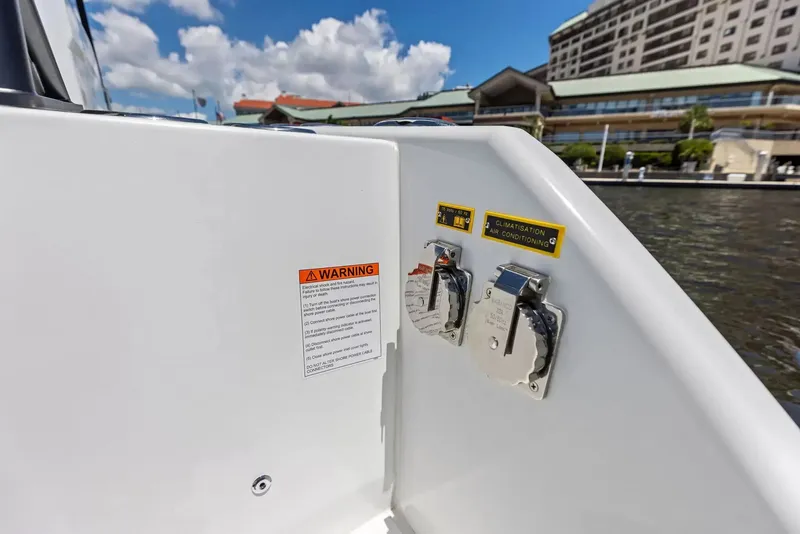 Slide: The Image of Close-up of connectors and warning labels on a boat, with buildings in the background. - 6