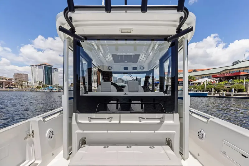 Slide: The Image of The image shows the stern of a Wellcraft 28 Explorer boat, with a view of the interior and cityscape. - 12