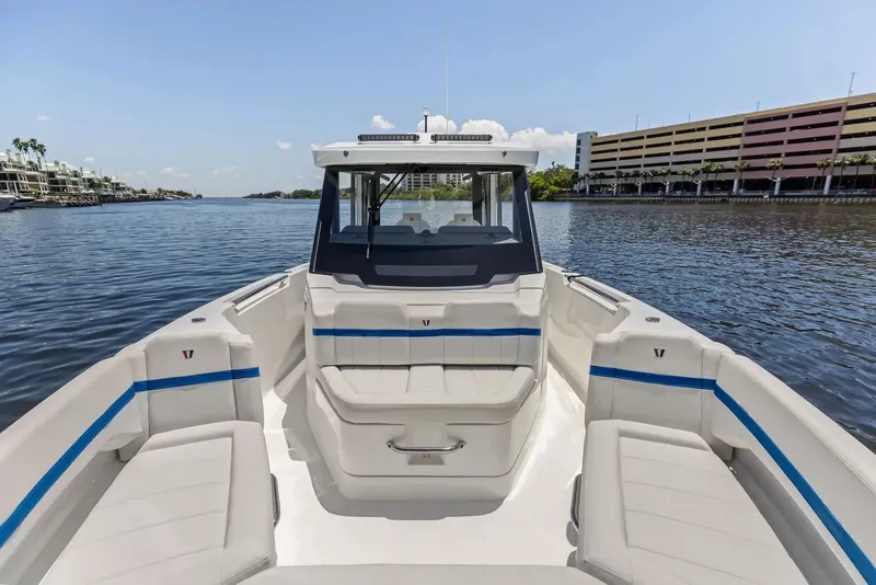 Slide: The Image of The image shows a modern boat with white seating and blue accents on calm waters. - 27
