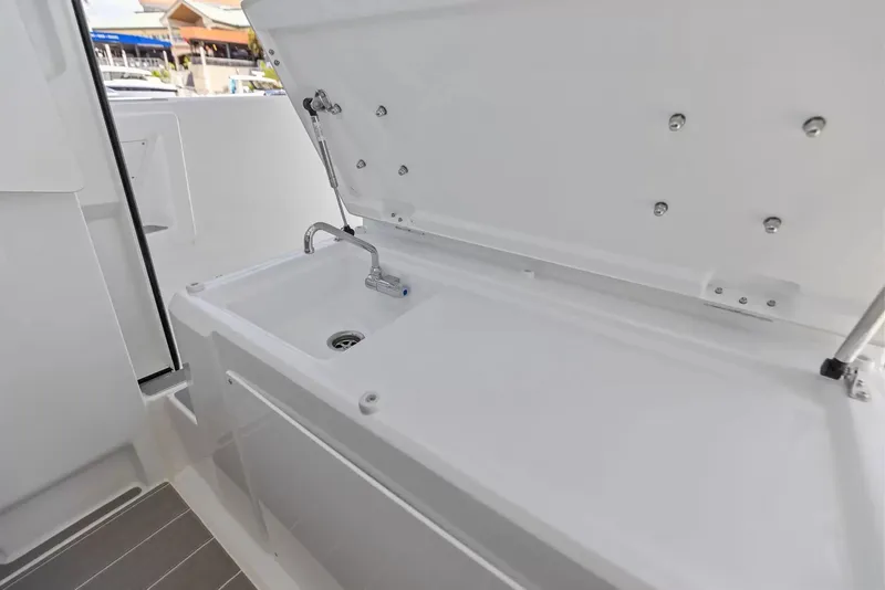 Slide: The Image of The 2027 Wellcraft 28 Explorer features a white sink with a faucet and drain. - 23