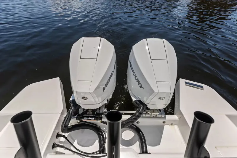 Slide: The Image of Two Mercury outboard engines are mounted on the stern of a boat, floating on calm water. - 5