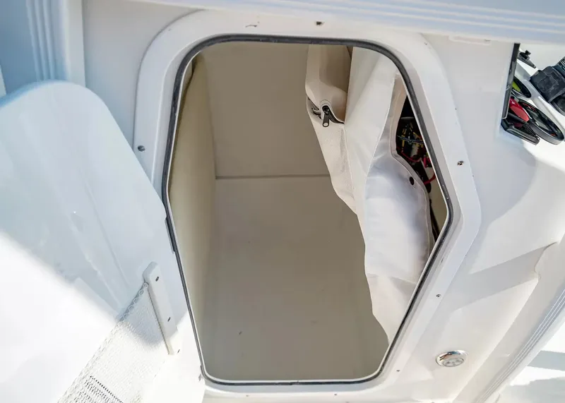 Slide: The Image of An open storage compartment on a Sea Hunt Ultra 229 boat, revealing a spacious interior. - 13
