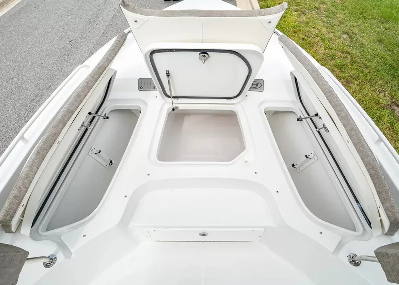Slide: The Image of The image shows the storage area of a 2027 Sea Hunt BX25FS boat with open hatches. - 22