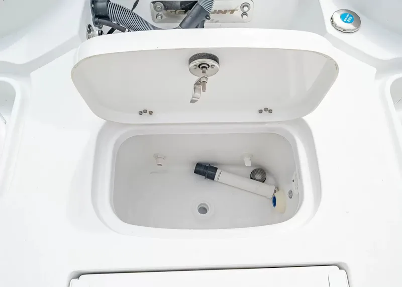 Slide: The Image of An open compartment on a boat reveals a white container with a hose and valve. - 8