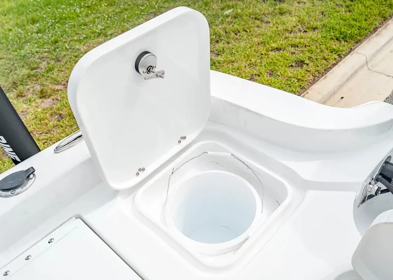 Slide: The Image of An open storage compartment on a 2027 Sea Hunt BX25FS boat, featuring a round container. - 7