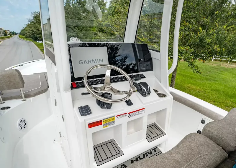 Slide: The Image of The image shows the helm of a Sea Hunt BX25FS boat. It features a Garmin navigation system and a modern steering wheel. - 14