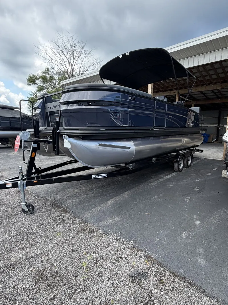 Slide: The Image of A 2027 Sylvan L3 RLZ Platinum pontoon boat on a trailer in a storage area. - 3