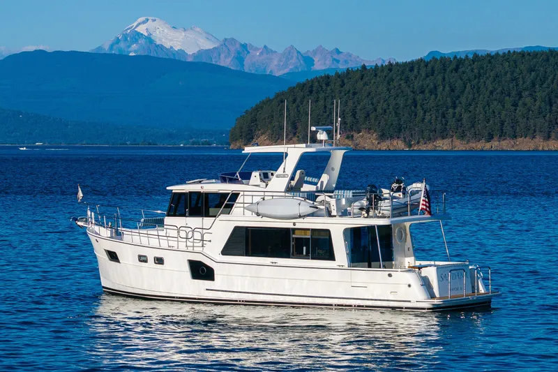 Slide: The Image of 2023 North Pacific 53 Euro yacht cruising on a serene lake with mountain backdrop. - 86