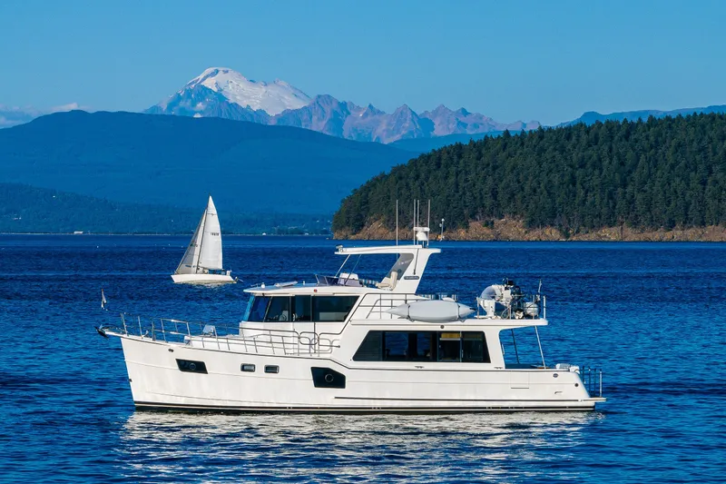 Slide: The Image of 2023 North Pacific 53 Euro yacht on serene blue waters with scenic mountain backdrop. - 87