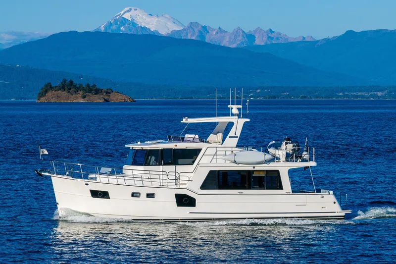 Slide: The Image of 2023 North Pacific 53 Euro yacht cruising on a scenic blue ocean with mountains. - 5