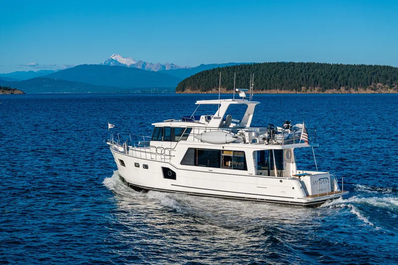 Slide: The Image of 2023 North Pacific 53 Euro yacht cruising on scenic blue waters with mountainous backdrop. - 105