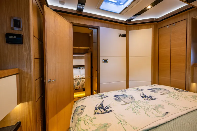 Slide: The Image of Luxurious 2023 North Pacific 53 Euro yacht bedroom with elegant wood paneling and fish-themed bedding. - 45