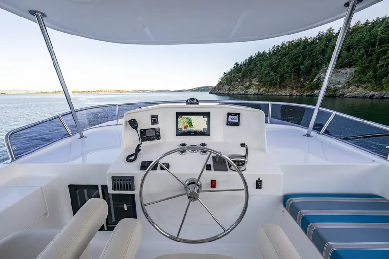 Slide: The Image of Helm of 2023 North Pacific 53 Euro yacht with navigation equipment, overlooking scenic waters. - 56