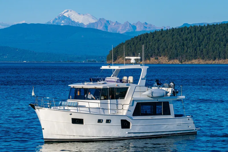 Slide: The Image of 2023 North Pacific 53 Euro yacht cruising on scenic blue waters with mountain backdrop. - 89