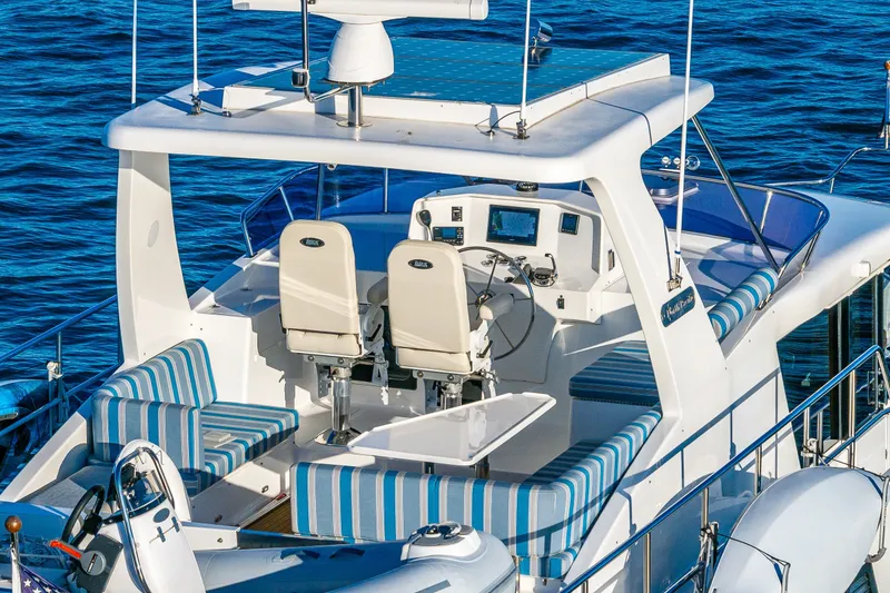 Slide: The Image of Flybridge of 2023 North Pacific 53 Euro yacht with striped seating and helm station. - 51