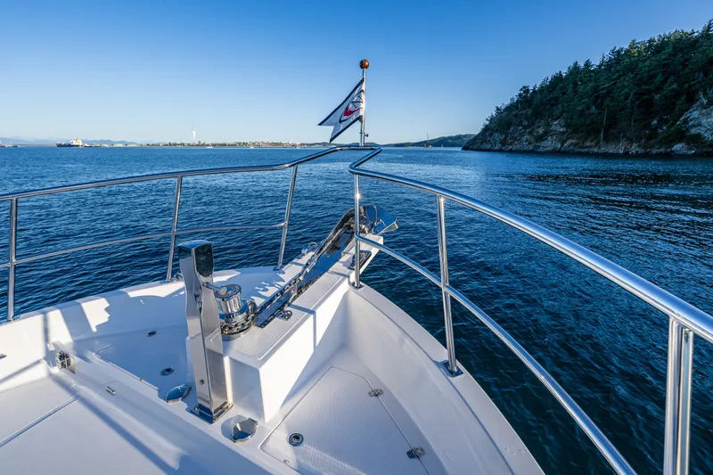 Slide: The Image of Bow view of 2023 North Pacific 53 Euro yacht cruising near forested coastline. - 65