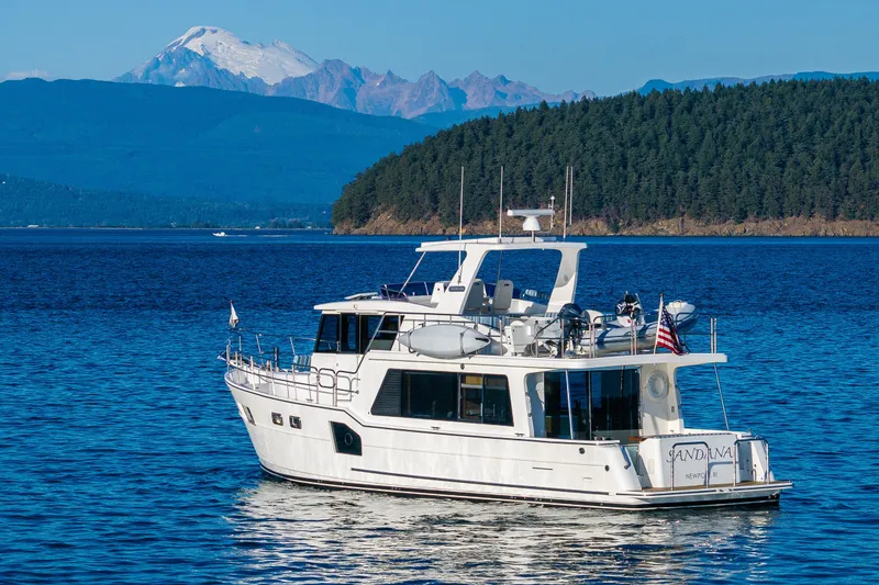Slide: The Image of 2023 North Pacific 53 Euro yacht on serene water with mountain backdrop. - 1