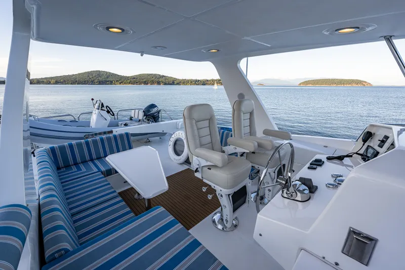 Slide: The Image of Luxurious 2023 North Pacific 53 Euro yacht interior with seating and helm, overlooking serene waters. - 54