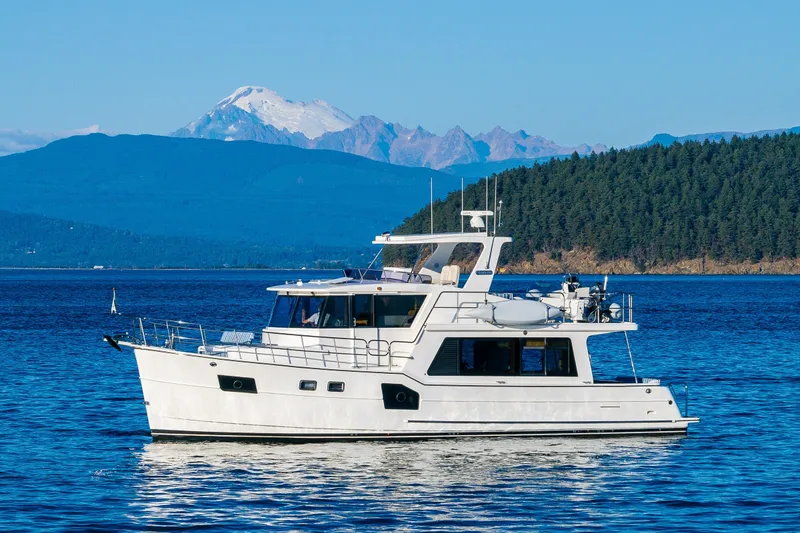 The Image of 2023 North Pacific 53 Euro yacht cruising on a serene lake with mountain backdrop. - 0