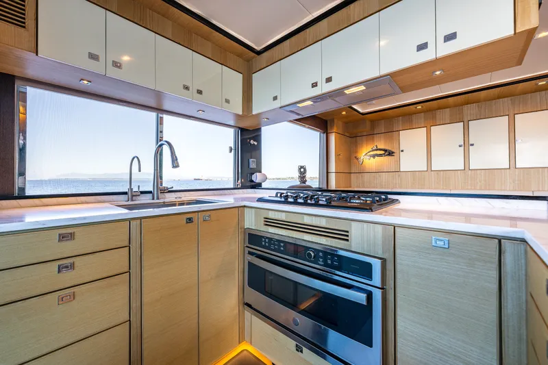 Slide: The Image of Modern kitchen interior on 2023 North Pacific 53 Euro yacht, featuring sleek cabinetry and ocean view. - 12