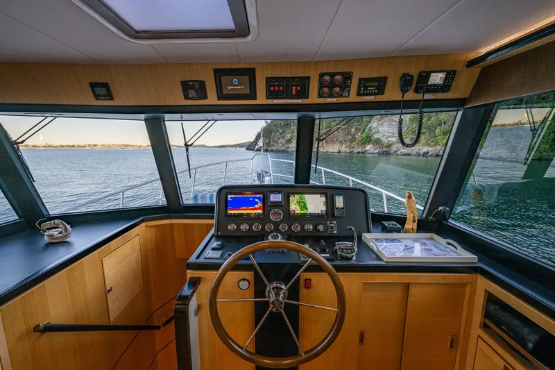 Slide: The Image of 2023 North Pacific 53 Euro yacht helm with navigation equipment and scenic waterway view. - 21