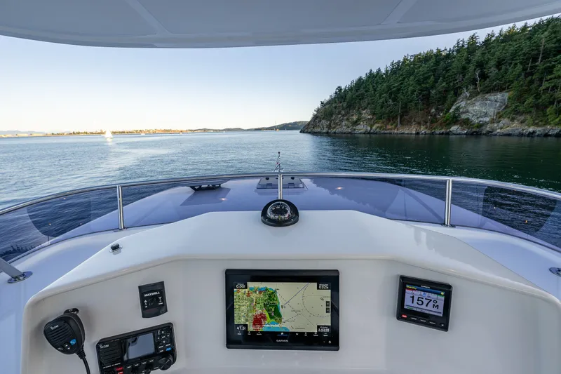 Slide: The Image of Cockpit view of 2023 North Pacific 53 Euro yacht navigating scenic coastal waters. - 57
