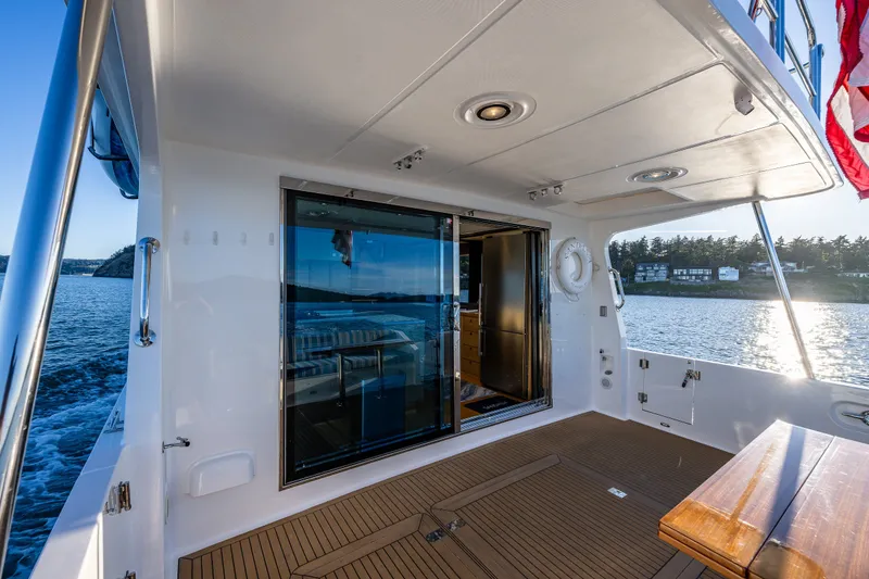 Slide: The Image of 2023 North Pacific 53 Euro yacht deck with sliding glass door and scenic water view. - 74
