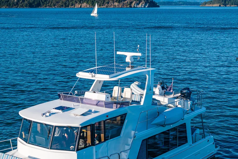 Slide: The Image of 2023 North Pacific 53 Euro yacht cruising on a serene blue ocean with a distant sailboat. - 92