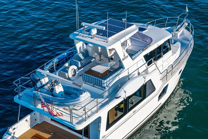 Slide: The Image of 2023 North Pacific 53 Euro yacht cruising on open water, featuring spacious deck and seating. - 97