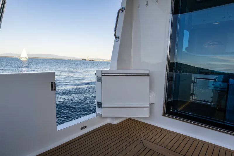 Slide: The Image of 2023 North Pacific 53 Euro yacht deck with ocean view and sailboat in distance. - 73