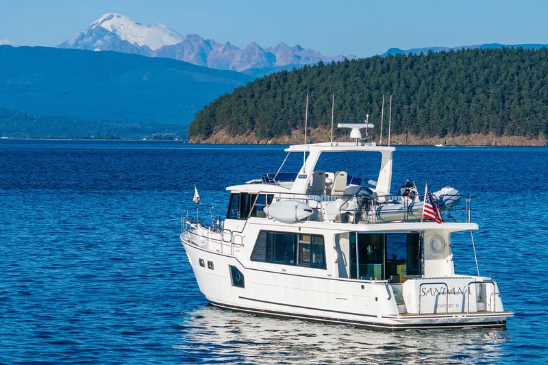 Slide: The Image of 2023 North Pacific 53 Euro yacht on serene blue waters with scenic mountain backdrop. - 4