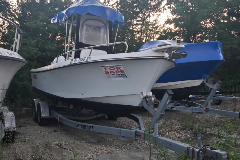 Slide: The Image of 2015 May-Craft 2300 CCX boat for sale on trailer, parked outdoors. - 13