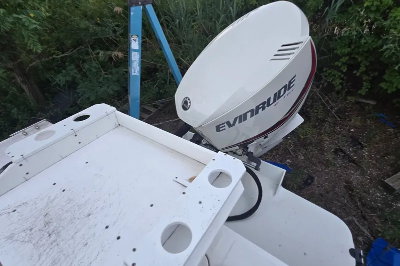 Slide: The Image of 2015 May-Craft 2300 CCX boat with Evinrude outboard motor in a wooded area. - 22