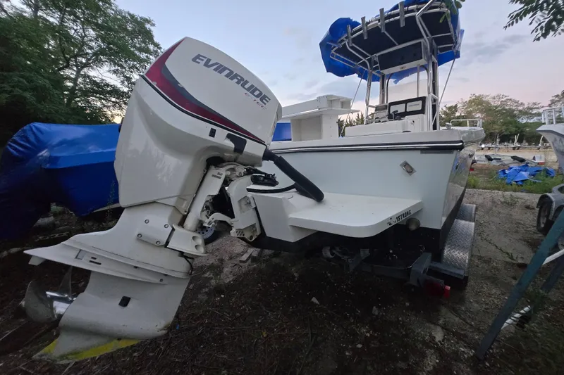 Slide: The Image of 2015 May-Craft 2300 CCX boat with Evinrude outboard motor, docked outdoors. - 20