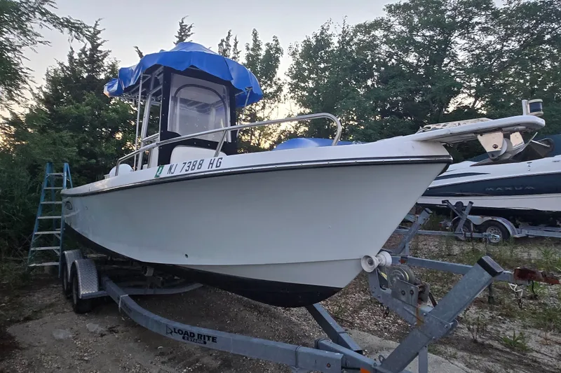 Slide: The Image of 2015 May-Craft 2300 CCX boat on trailer, surrounded by trees. - 19