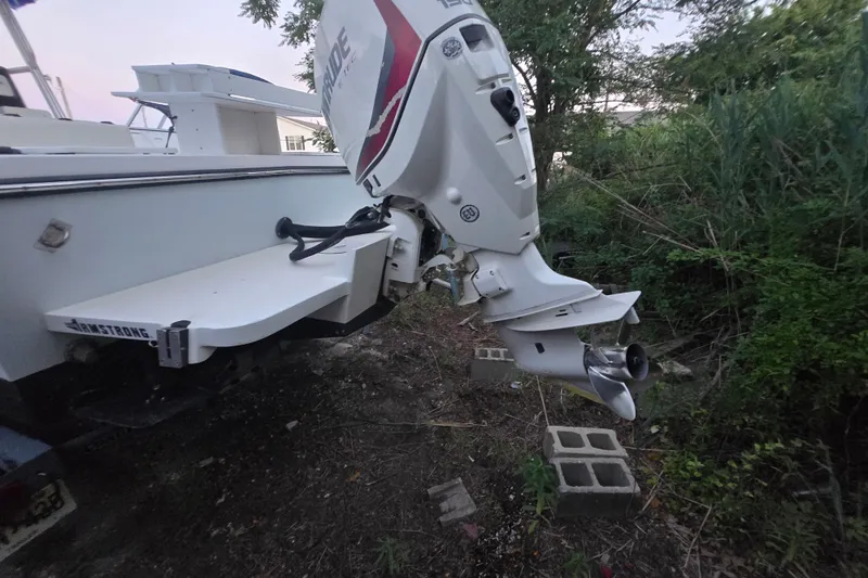 Slide: The Image of 2015 May-Craft 2300 CCX boat with Evinrude outboard motor, parked on land. - 21