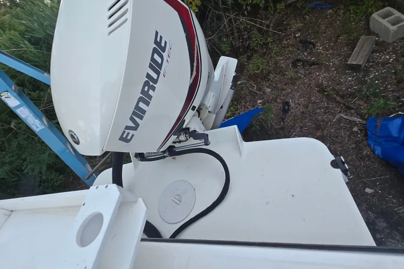 Slide: The Image of 2015 May-Craft 2300 CCX boat with Evinrude E-TEC outboard motor, docked outdoors. - 23