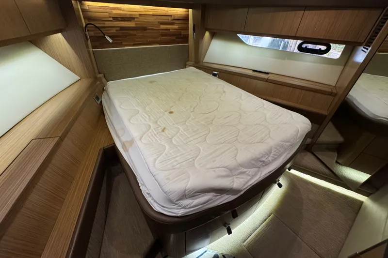 Slide: The Image of Luxurious cabin interior of 2016 Sea Ray L590 yacht with cozy bed and wooden accents. - 28