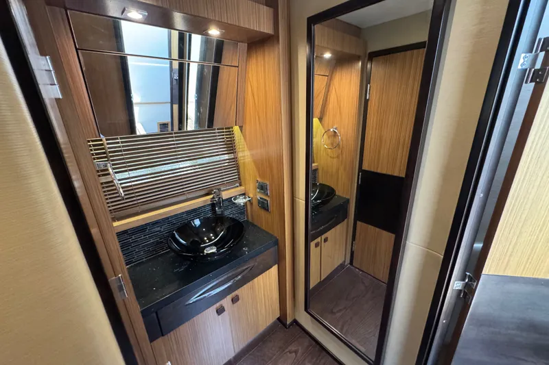 Slide: The Image of Luxurious 2016 Sea Ray L590 yacht bathroom with modern sink and wood accents. - 25